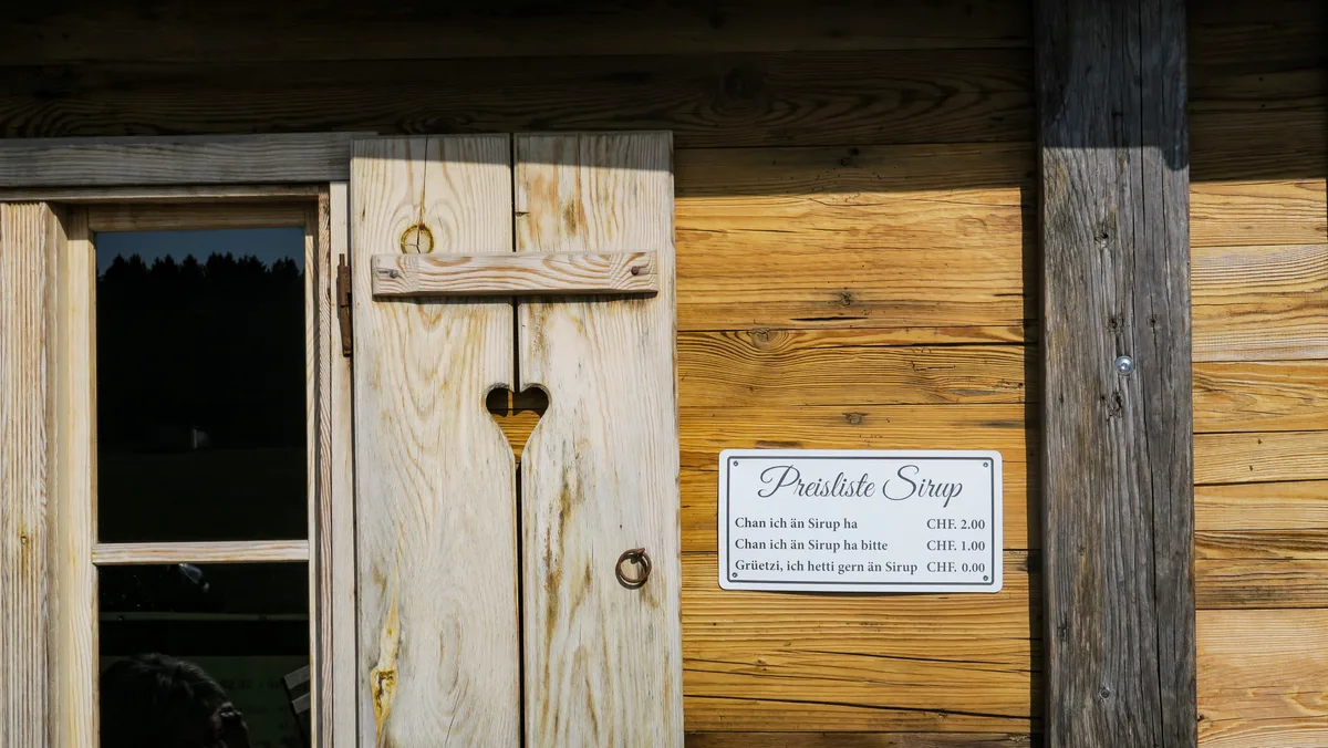 Auch mit dem Ersatzneubau soll das familiäre Ambiente des Restaurants «Im Speck» erhalten werden. Man sieht eine kleine Alutafel neben einem Fensterladen.